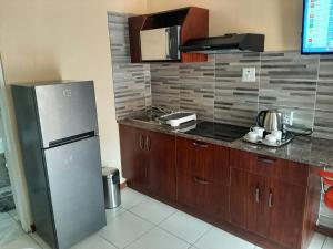 La cuisine est équipée d'un réfrigérateur en acier inoxydable et de placards en bois. dans l'établissement Lesedi Self Catering, à Pretoria