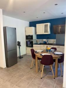 a kitchen with a table and chairs and a refrigerator at Maison cosy centre de Nîmes in Nîmes