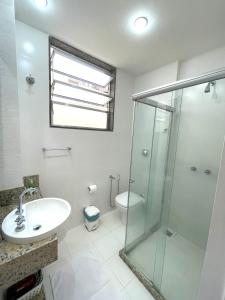 a bathroom with a glass shower and a sink at Point de Ipanema - 2 quartos in Rio de Janeiro