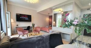 a living room with a couch and chairs and a television at DK Premium Romantyczna Secesja in Olsztyn