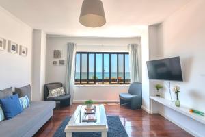 a living room with a couch and a tv at Espinho Guesthouse - Sea View Apartment in Espinho