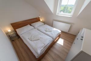 a bedroom with a bed with white sheets and a window at Apartmán U Berty Třeboň in Třeboň
