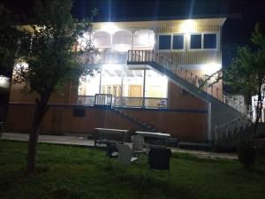 a building with stairs and a table in a yard at night at Neelum Good View in Shardi