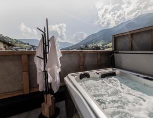 d'une baignoire installée au-dessus d'un balcon. dans l'établissement FRAU GANS - pure mountain apartments, à Saalbach-Hinterglemm