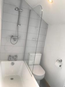 a bathroom with a tub and a toilet and a mirror at No 6 Elizabeth Street in Congleton