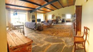 a living room with a stone floor and a living room with a couch at Oliveirinha Country House in Évora