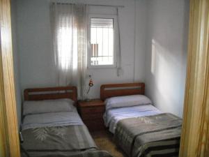 two beds in a small room with a window at Casa Rural Singra in Singra