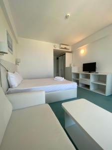 a white room with two beds and a tv at Gabriela Blaxy Apartamente in Olimp