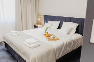 a large white bed with a tray of food on it at Molto Bene Hotel & Restaurant in Skórcz