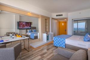 a bedroom with a bed and a living room at Amara Comfort Resort in Kemer