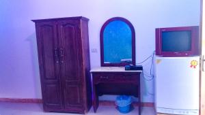 a room with a desk and a tv and a refrigerator at Octopus Hotel in Dahab