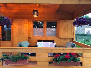 a porch with a couch and some plants and windows at Black Horse in Pasłęk
