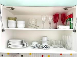 a cupboard filled with plates and glasses and dishes at Point de Ipanema - 2 quartos in Rio de Janeiro