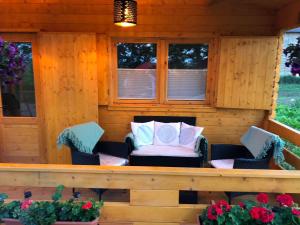a porch with a couch and chairs in a cabin at Black Horse in Pasłęk