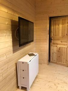a room with a television on a wall with a white box at Black Horse in Pasłęk