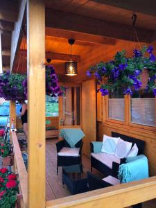 a porch with a couch and chairs and flowers at Black Horse in Pasłęk