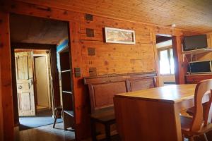 uma cozinha com paredes de madeira e uma mesa num quarto em CHARMIEUX appartement en chalet typique em Le Grand-Bornand