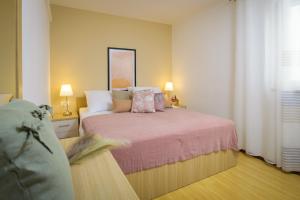 a bedroom with a bed with pink sheets and pillows at Lavica Seaside Apartments, Podstrana in Podstrana