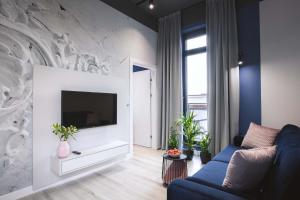 a living room with a blue couch and a tv at Luxo apartments 14 in Jelenia Góra