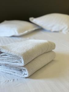 una pila de toallas sentadas encima de una cama en Centre de Beausoleil, climatisé, Wifi, terrasse., en Beausoleil