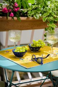 a table with two glasses and two bowls of grapes at Lavica Seaside Apartments, Podstrana in Podstrana