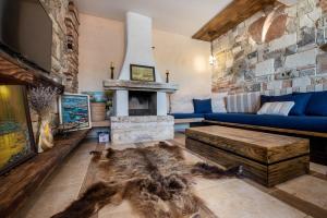 sala de estar con sofá azul y chimenea en Villa Cook with Sea View - Heated Pool - at Balchik, en Balchik