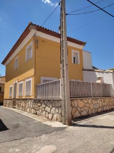 una casa amarilla al lado de una calle en El Rincón de Dorotea - Casa rural, en Villalba de la Sierra