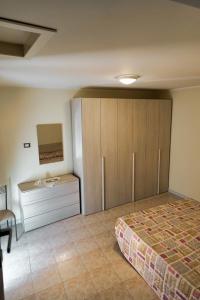 um quarto com uma cama, uma cómoda e um armário em casa vacanza centro storico fornelli em Fornelli