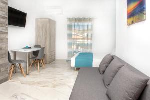 a living room with a couch and a bed and a table at XD Central Apartments in Ierissos
