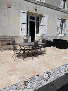 a patio with a table and chairs in front of a building at La Tourterelle in Thaims
