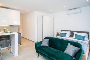 a living room with a green couch in front of a bed at Corallium Precious in Pomena