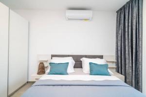 a bedroom with a large bed with blue pillows at Corallium Precious in Pomena +29 photos