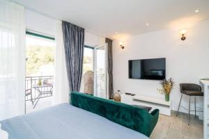 a bedroom with a bed and a tv on a wall at Corallium Precious in Pomena