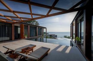 a house with a view of the ocean on the balcony at The Naka Phuket, a member of Design Hotels in Kamala Beach