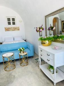 salon z niebieską kanapą i lustrem w obiekcie Villa Kastelli88 Santorini Pyrgos w mieście Pirgos
