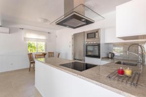 cocina con encimera y fogones horno superior en Casa Vistas Axarquia, en Vélez-Málaga