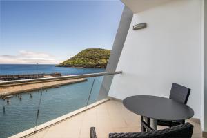 Un balcón con mesa y sillas y vista al mar. en Angra Marina Hotel, en Angra do Heroísmo