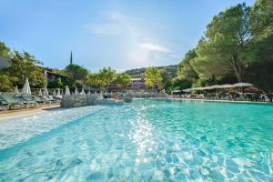 ein großer Pool mit blauem Wasser in einem Resort in der Unterkunft SOWELL HOTELS Ardèche in Grospierres