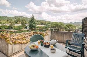 a table with a bowl of fruit on a balcony at SOWELL HOTELS Ardèche in Grospierres