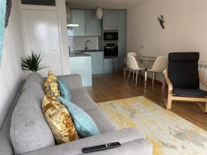 sala de estar con sofá con almohadas y cocina en Vitamin Sea with a Sea View and Parking, en Lyme Regis