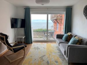 sala de estar con sofá y vistas al océano en Vitamin Sea with a Sea View and Parking, en Lyme Regis