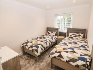 a bedroom with two beds and a window at Bwthyn Eirlys Snowdrop Cottage in Cemaes Bay