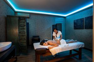 a woman in a room with a woman laying on a bed at Donna Carmela Resort & Lodges in Riposto
