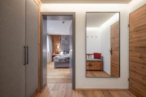 a hallway with a mirror and a bedroom at Alpine Lodge by Apartment Managers in Kirchberg in Tirol