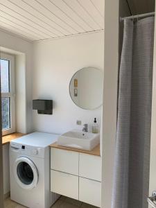 La salle de bains est pourvue d'un lave-linge et d'un lavabo. dans l'établissement 4 personers ferielejlighed, à Løkken