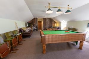 a living room with a pool table and chairs at The Old Cowshed in Kidwelly