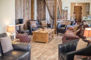 a living room with couches and a coffee table at The Old Cowshed in Kidwelly