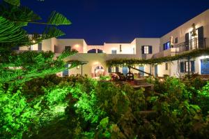 a large white house at night with green lights at Agios Prokopios Hotel in Agios Prokopios