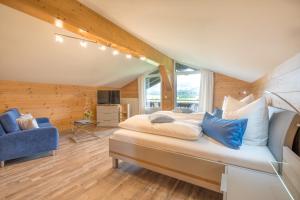 ein Schlafzimmer mit einem großen Bett und einem blauen Stuhl in der Unterkunft Haus am Gaisalpbach in Oberstdorf
