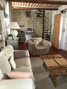 ein Wohnzimmer mit 2 Sofas und einem Couchtisch in der Unterkunft La Charmeuse in Céreste